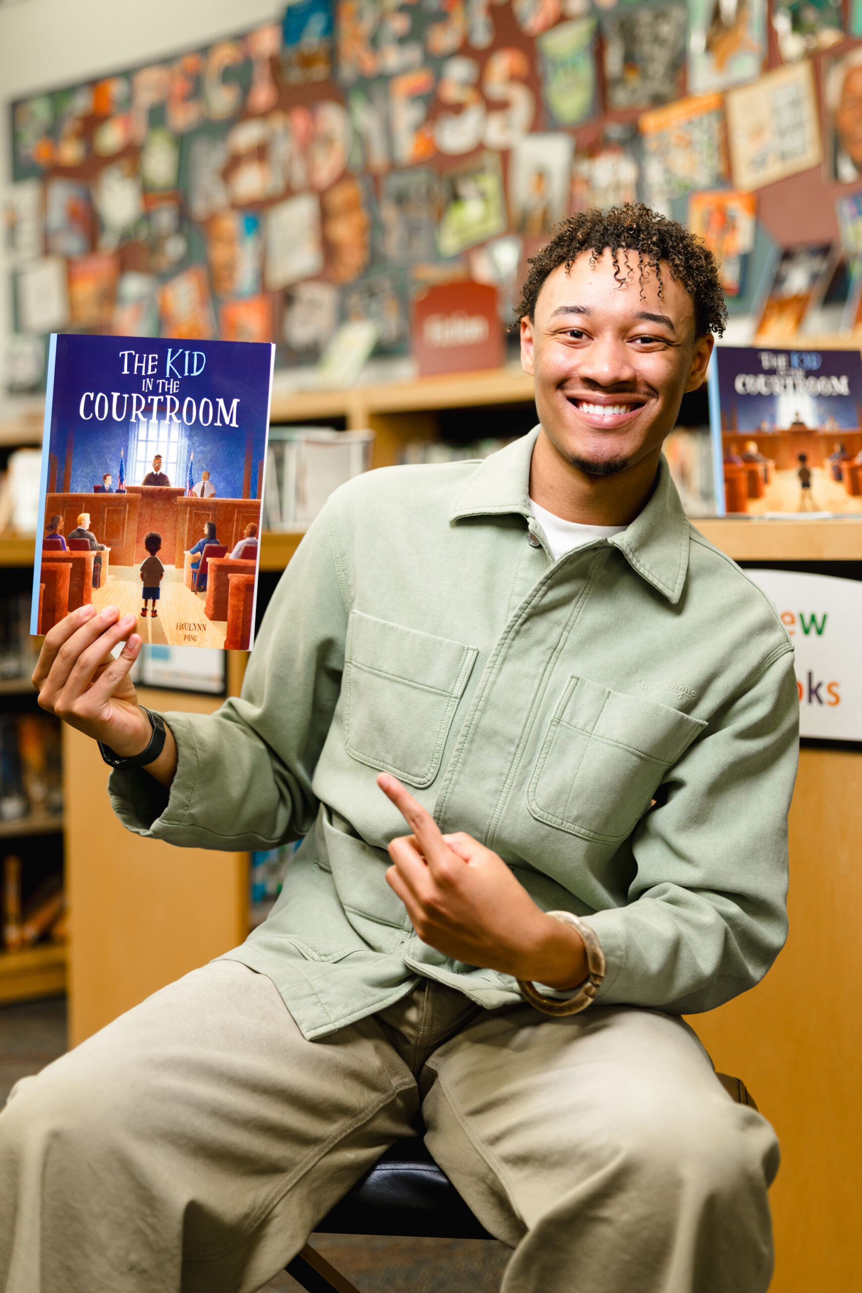 Cayden Brown poses with his debut book The Kid in the Courtroom